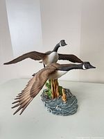 Front view of two geese figurine on base