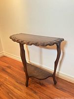 Full front view of demilune table showing legs and lower shelf