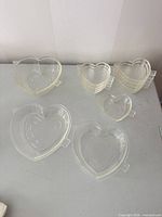 Stacked clear glass heart dishes showing two sizes