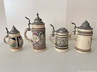 Group view of all four ceramic beer steins with pewter lids