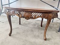 Side view showing pierced lattice apron, central shell carving and cabriole legs