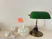 Full view of bankers lamp, milk glass candy dish and two hen dishes