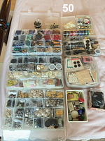 Multiple clear organizer boxes filled with buttons, snaps, beads, fasteners, spools, eyelets