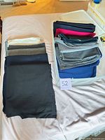 Bin with folded wool fabrics in multiple colors and additional pieces laid out