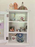 Overall view of white curio cabinet and all contents