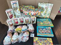 Group shot of all boxed figurines, plush dolls, puzzles and play sets