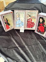 Four boxed Effanbee dolls displayed side by side