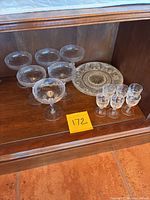 Overview of all glassware and one dessert plate on shelf