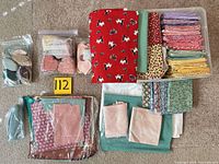 overview of tote contents including folded fat quarters, ziplock bags with fabric shapes, binding strips, scraps