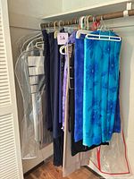 Hanger rod with multiple fabric pieces of various colors and prints in clear garment bags