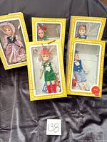 Five Effanbee dolls in yellow window boxes displayed together