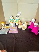 Group shot of all plush toys, Bam Bam figure, booklet
