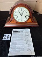 Front view of Howard Miller mantel clock with manual and key visible