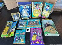 All ten boxed Snow White dolls and figurine sets laid out on table
