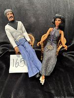Both Sonny and Cher dolls seated in wicker chairs showing full outfits