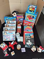 Overall view showing boxed games, VHS sets, books, toys, figurines, cups and snow globe