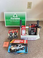 All accessories on carpet including Futaba insert, wheels, field box, Porsche booklet