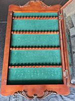 Door open showing green felt interior and spoon slots