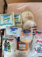 All eight sealed packages of pillow inserts, fiber fill and quilt batting displayed on bed