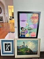 Group shot of all three framed artworks standing against wall