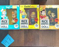 Front view of three boxed Kellogg’s Snap, Crackle, Pop Rice Krispies dolls