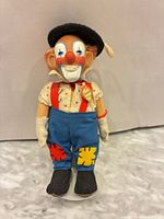 Full front view of Steiff Clownie doll on stand
