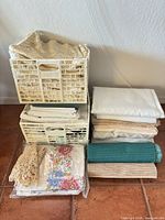 Stacked crates holding folded tablecloths, runners and placemats