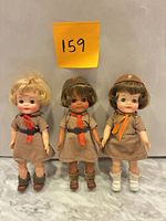 Front view of all three Effanbee Brownie dolls standing on marble surface