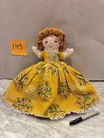 Front view of ragdoll showing dress pattern, yarn hair, embroidered face