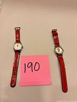 Front view of both Mickey Mouse wristwatches with red straps