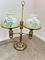 Full view of brass double student lamp with twin floral glass shades and chimneys