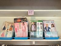 Three bins filled with assorted vintage sewing pattern envelopes from Simplicity, New Look, Kwik Sew