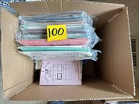 Box containing stacked plastic-wrapped pattern envelopes with lot tag