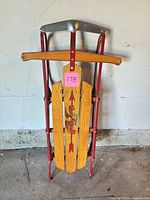 Front view of Flexible Flyer wood and steel sled showing graphics and steering bar