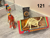 Group shot of all three items: duck clown toy, boxed dinosaur, packaged yo-yo