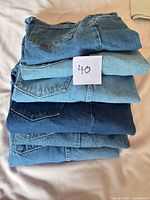 Stack of six folded Wrangler jeans showing color variation