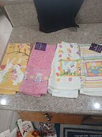 Four towels laid out showing overall designs and hang tags