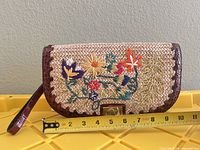 Front of wristlet showing floral embroidery and length measurement