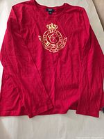 Front view of red Chaps long sleeve shirt showing gold crest logo