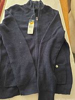 Front view of navy ribbed sweater with tags attached