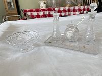 Full view of crystal set: tray with two bottles, lidded jar and spoon, separate footed bowl