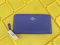 Front view of Coach purple leather wallet with tag attached