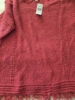 Full view of dusty rose knit sweater showing texture and fringe hem