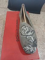 Top view of right shoe on box showing suede upper and floral design