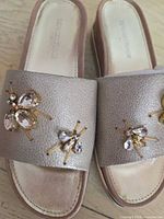 Top view of both sandals showing leather uppers and crystal insect embellishments