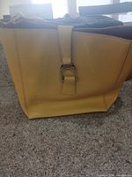 Front view of yellow saffiano leather tote showing buckle detail