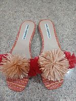 Top view showing both sandals, woven fabric and pom-pom details