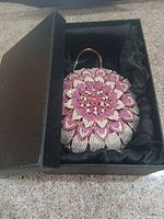 Clutch in original presentation box showing rhinestone floral front
