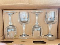 Four crystal wine glasses in original shipping carton, upside-down showing etched floral design
