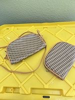 Two patterned canvas crossbody bags front view on yellow surface
